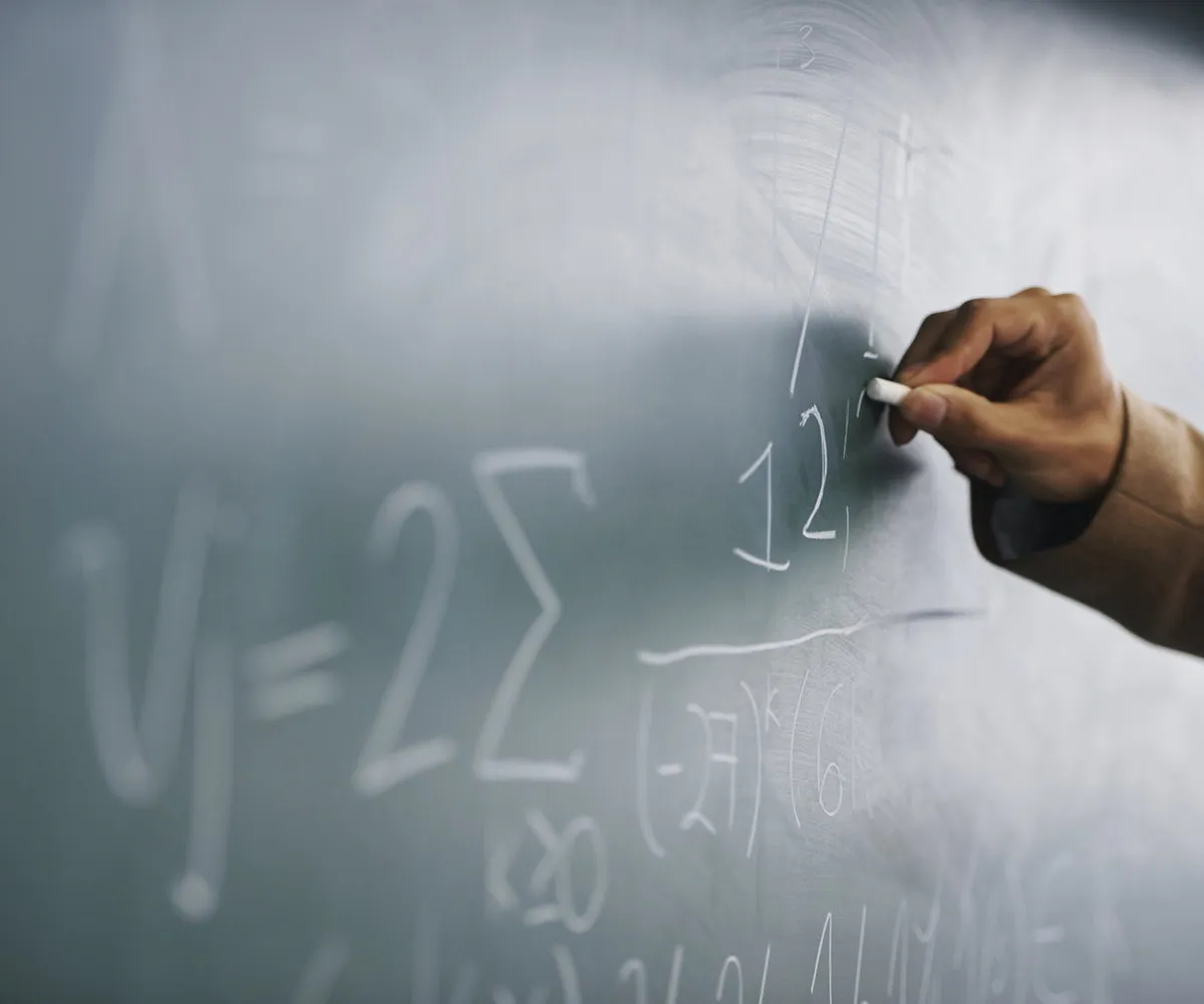 Working through a maths problem on a chalkboard